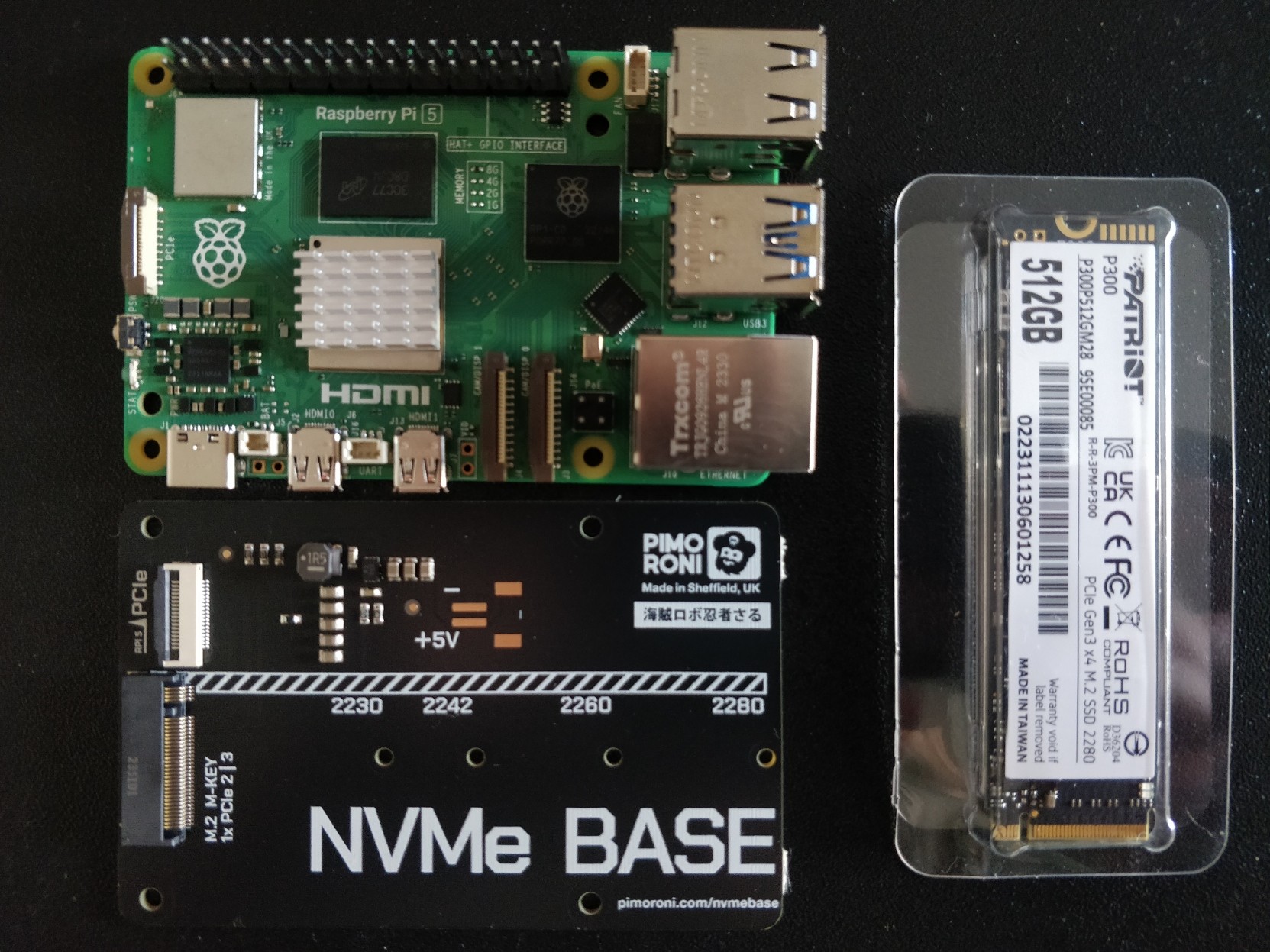 A photograph showing an arrangement of a Raspberry Pi 5, Pimoroni NVMe base and a 500GB NVMe solid state drive.
